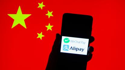 A silhouetted smartphone shows the logos of WeChat Pay and Alipay, with a Chinese flag in the background