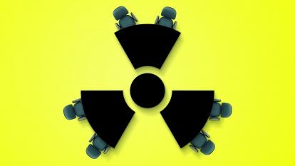 A nuclear hazard sign on a yellow background, with office chairs parked around the edge, as if it were a meeting room table