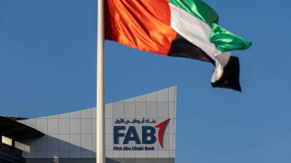 A flag of the UAE in front of the logo of First Abu Dhabi Bank