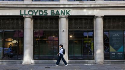 A woman walks in front of a branch of Lloyds Bank