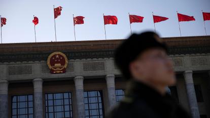 A Chinese soldier is seen as flags wave at the Great Hall of the People in Beijing, China