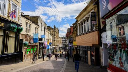 A pedestrianised UK high street flanked by small businesses