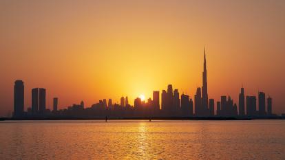 The sun sets behind the Dubai skyline