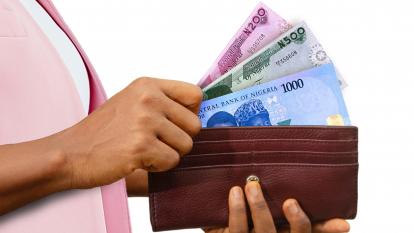Woman producing the new naira notes from a wallet