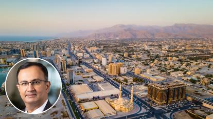 Cityscape of Emirate of Ras Al Khaimah with inset portrait of Rakbank chief executive Raheel Ahmed