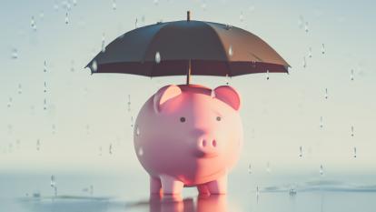 Umbrella over piggy bank